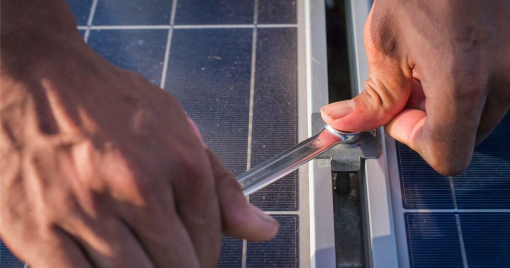 un homme réparant des panneaux solaires