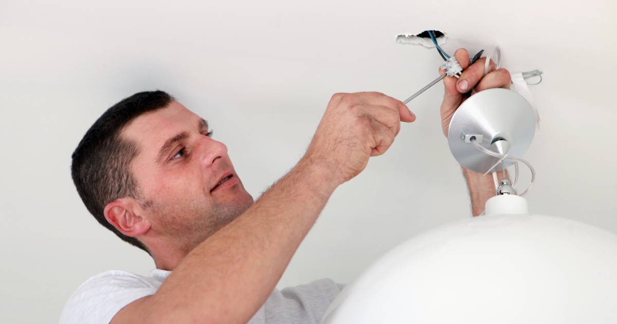 Homme installant un luminaire en porcelaine