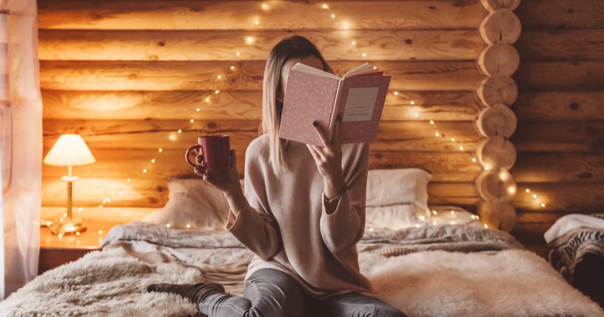 femme lisant un livre dans son chalet rustique