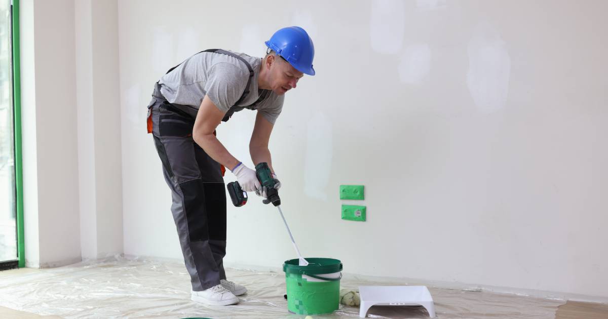 Homme préparant un mur pour le peindre