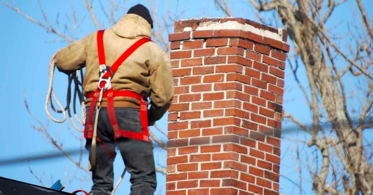 Homme ramonant une cheminée.